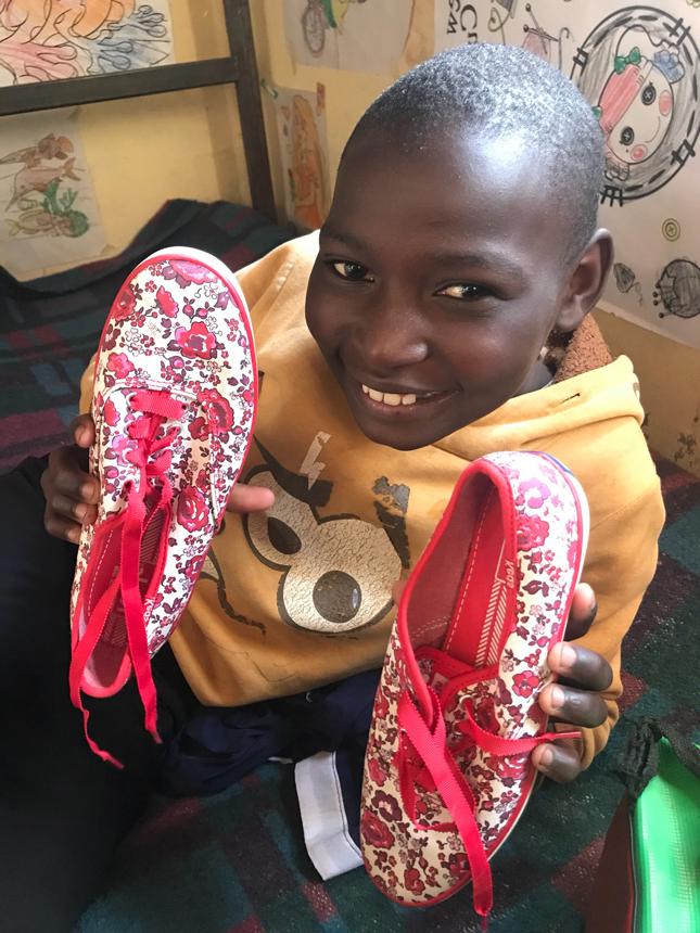 肯尼亚小孩拿着一双新鞋